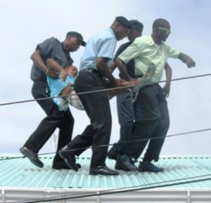 The Teen being taken off the roof. [iNews' Photo]