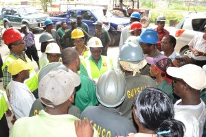 Minister in the Ministry of Social Protection Simona Broomes listens as factory workers express their concerns