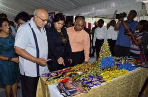 President Donald Ramotar gets an explanation about one of the products from Joint CEO of Sueria Manufacturing Inc., Teshawna Lall while Kaieteur News Publisher Glen Lall looks on.