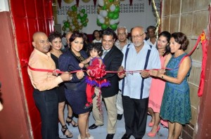 President Donald Ramotar assists in cutting the ribbon to officially open Sueria Manufacturing Inc.  Also in photo are Joint CEOs of the company, Teshawna Lall and Frank Sanichara, baby Sueria, First Lady Deolatchmee Ramotar and Kaieteur News’ Publisher Glen Lall